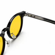 Melato Nox dagbril detail close-up – zwart acetate frame gele lens zilver scharnier blauwlichtfilter